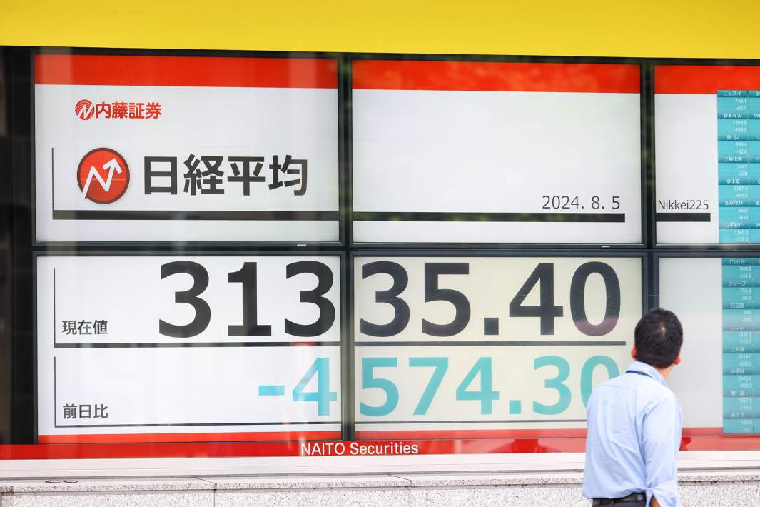 Японский фондовый индекс Nikkei, отображаемый на рекламном щите в Токио