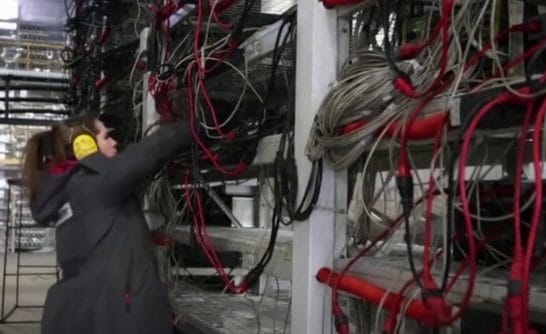 An engineer working in a Russian industrial crypto mining data center.